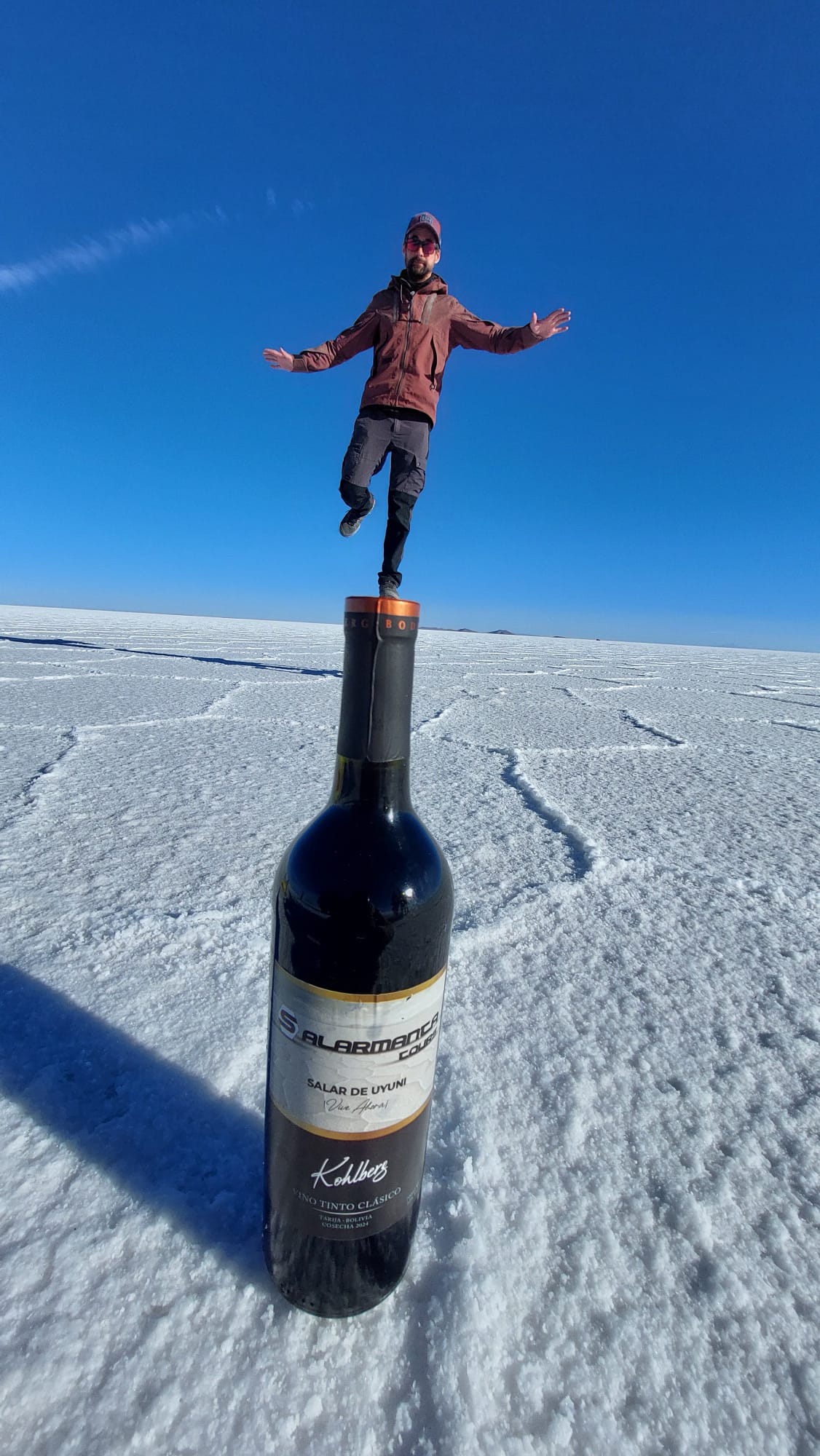 Jeu de perspective sur le salar : Thomas en équilibre sur une bouteille de vin