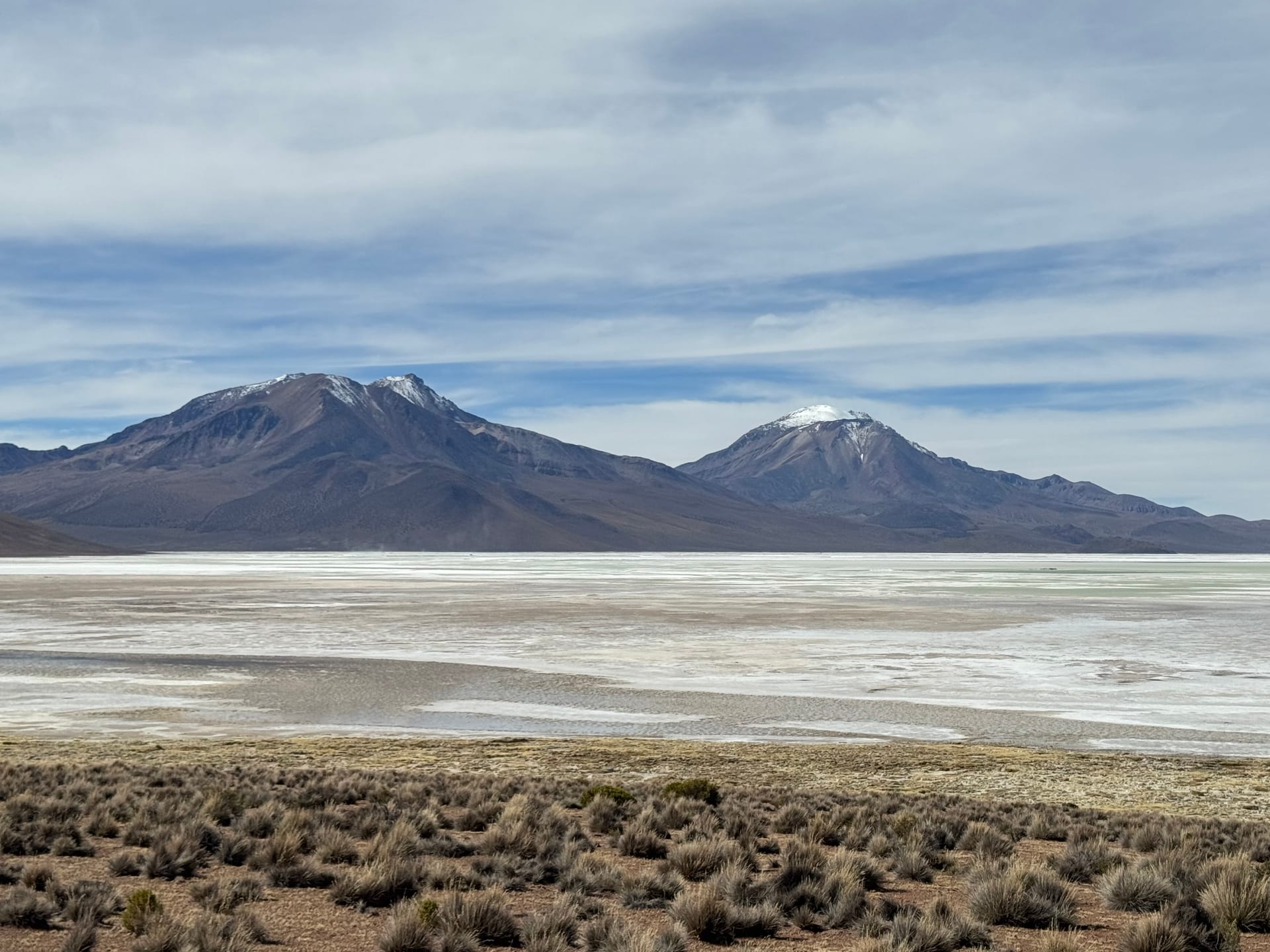 Salar blanc et volcans enneigés sur la piste entre la frontière bolivienne et Putre