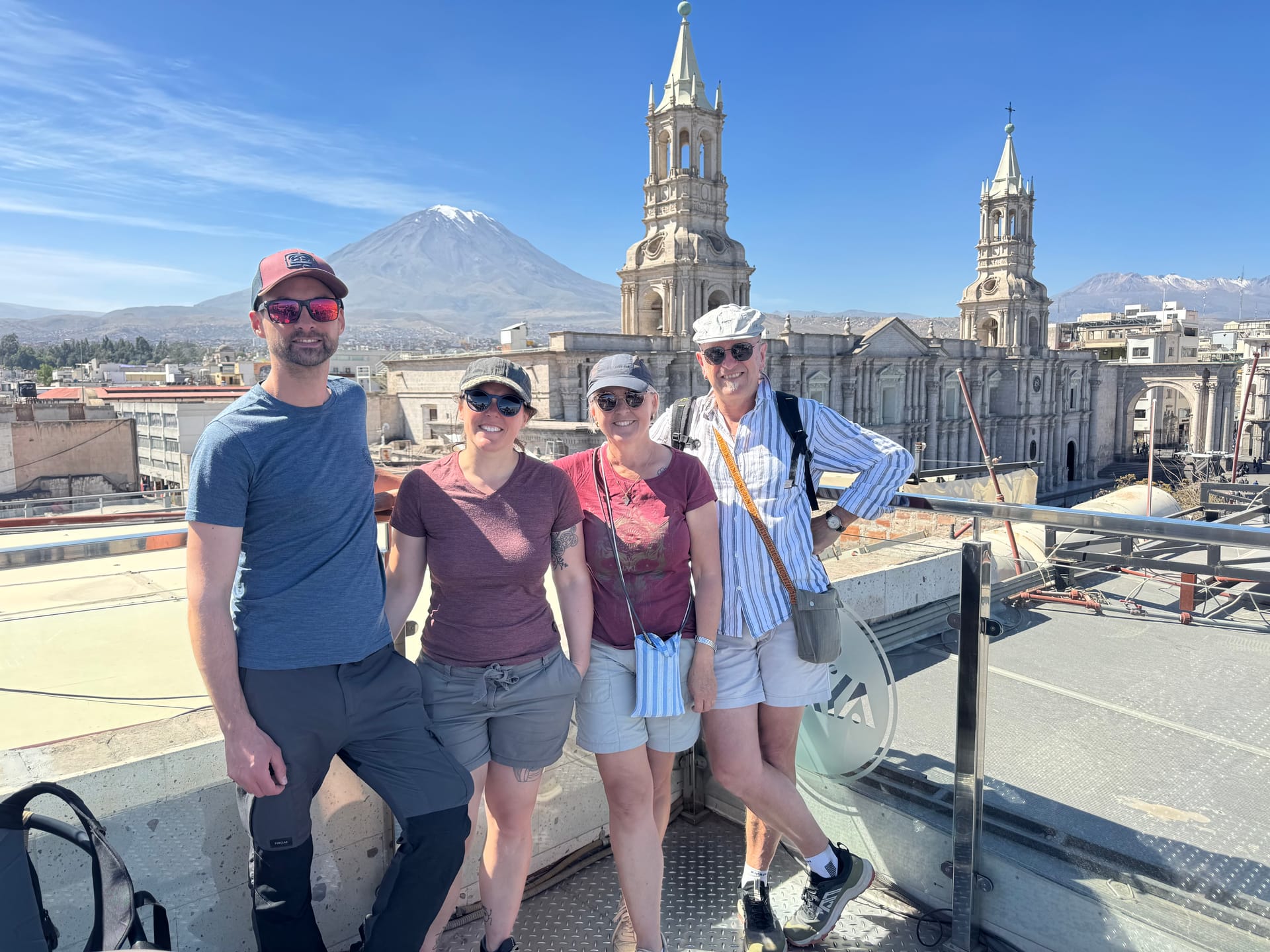 Thomas, Adeline et ses parents sur un toit-terrasse face à la cathédrale d'Arequipa et au volcan Misti