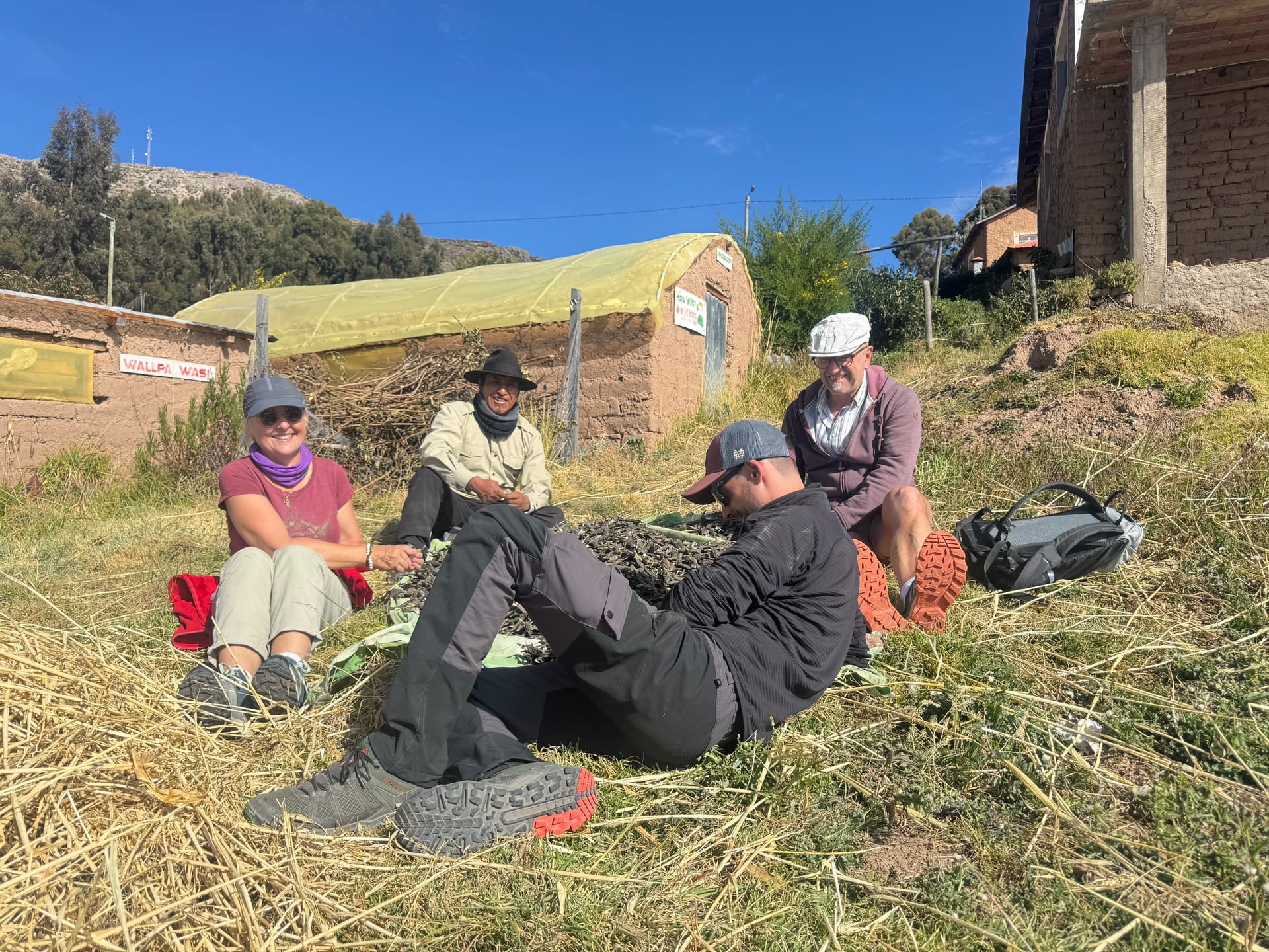 Thomas, Adeline et ses parents assis dans la paille avec la famille de Nestor sur l'île Amantani