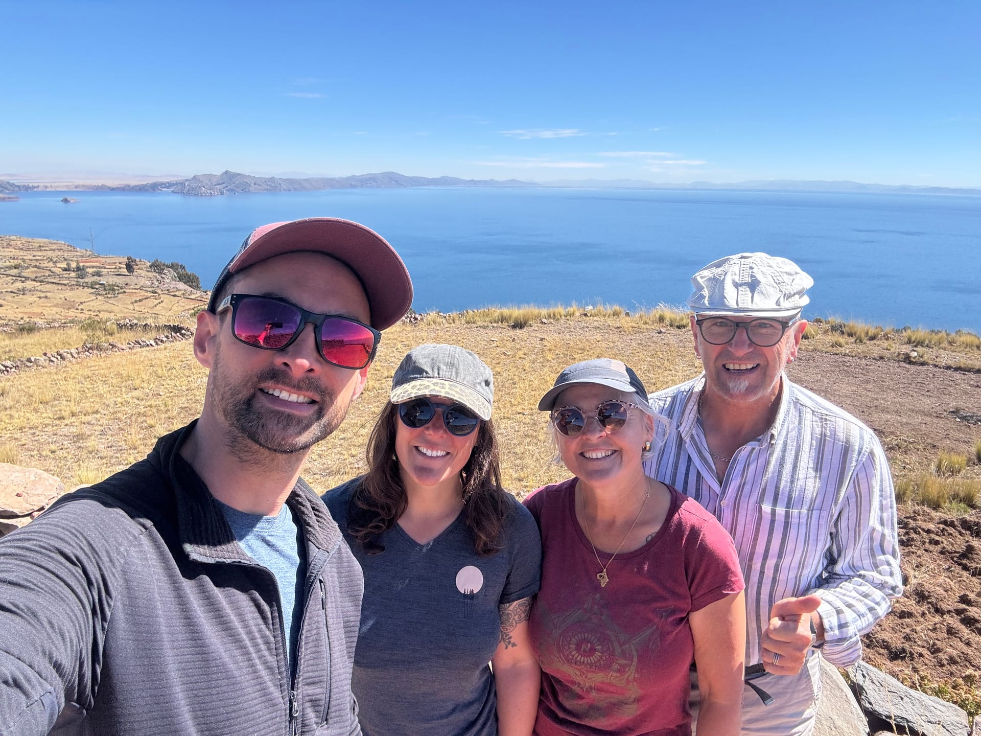 Selfie de Thomas, Adeline et ses parents au sommet de l'île Amantani, lac Titicaca derrière