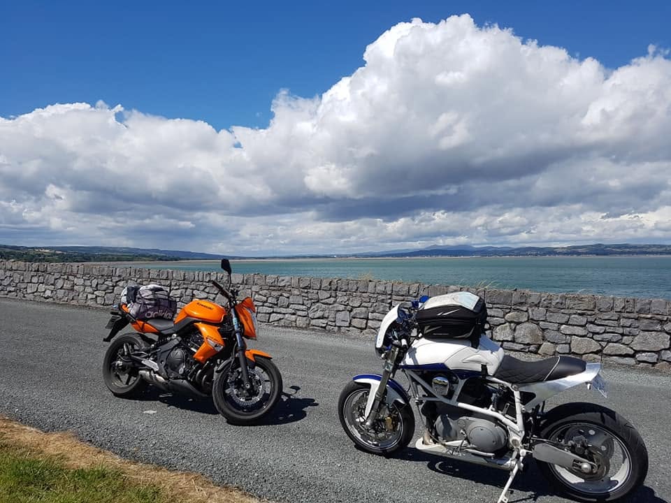 Nos deux motos chargées du matériel de camping, garées le long d'un muret face à la mer en Irlande